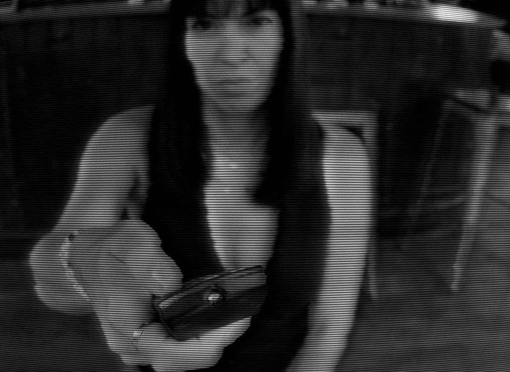 A woman point the remote control at the camera